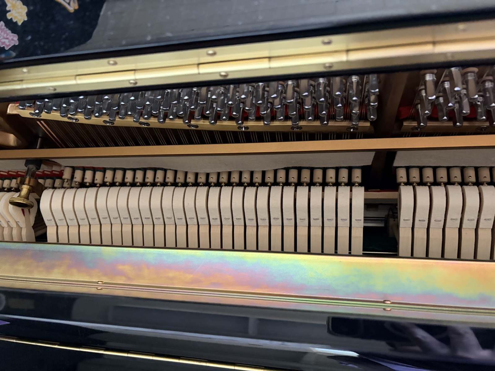 Detail of the Essex upright&rsquo;s action, with rows of felt hammers and dampers above the strings, seen through the open top lid